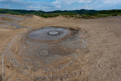 Mud volcanoes in Romania near the village of Berca Paclele Mici with greenery in the background photo