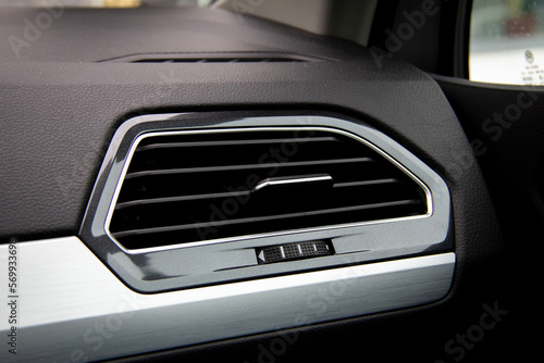 Ventilation exhaust in black car interior with metal frame