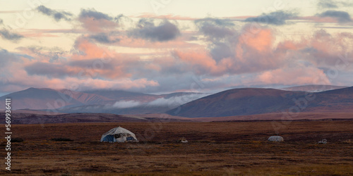 Picturesque arctic landscape. Yaranga (home of nomadic reindeer herders) in the tundra. The traditional way of life of the indigenous people of Chukotka. Russia. Morning panorama of the autumn tundra. photo