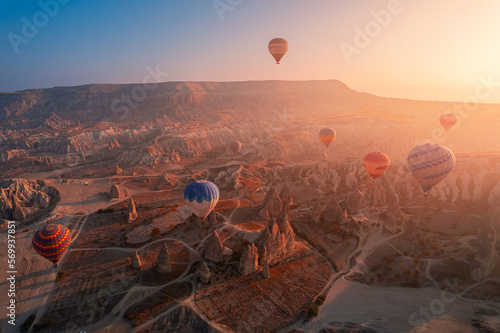 Amazing sunrise landscape in Cappadocia with colorful hot air balloon fly in sky over deep canyons, valleys. Turkey banner travel Concept
