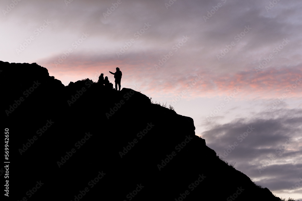 People silhouette on top of the hill