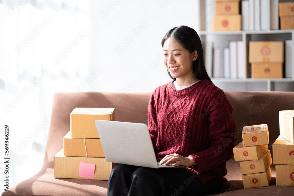 Startup small business entrepreneur of freelance Asian woman using a laptop with box Cheerful success online marketing packaging box and delivery SME idea concept. Startup small business entrepreneur of freelance Asian woman using a laptop with box Cheerful success online marketing packaging box and delivery SME idea concept.