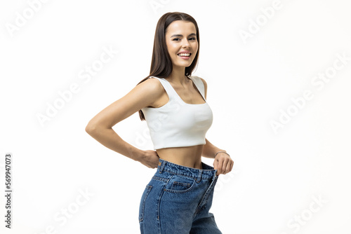 beautiful young woman with big jeans, isolated on white background