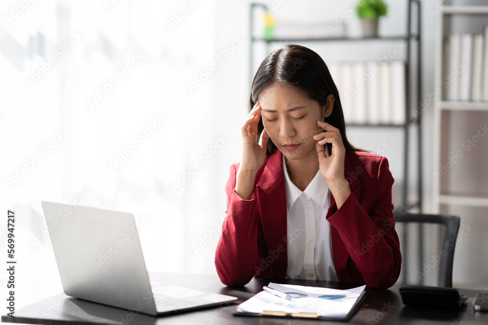 Tired Asian business woman with headache at office, feeling sick at work ater a busy day. Tired Asian business woman with headache at office, feeling sick at work ater a busy day.