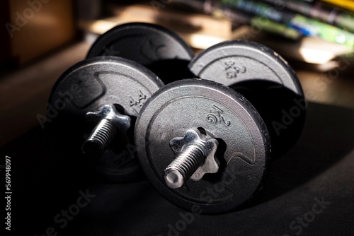 A close up portrait of two dumbbell weights lying on a small mat ready to be used for some healthy exercises for strength, stamina or to recover from an injury. Great for a new years resolution.