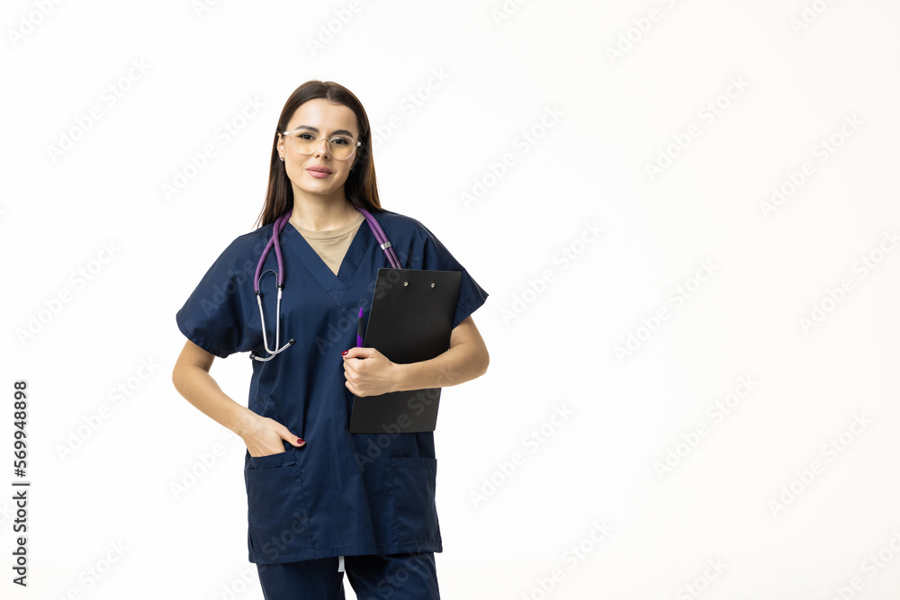 Smiling female doctor in lab coat with arms crossed looking away and posing against grey background. Medicine concept Smiling female doctor in lab coat with arms crossed looking away and posing against grey background. Medicine concept
