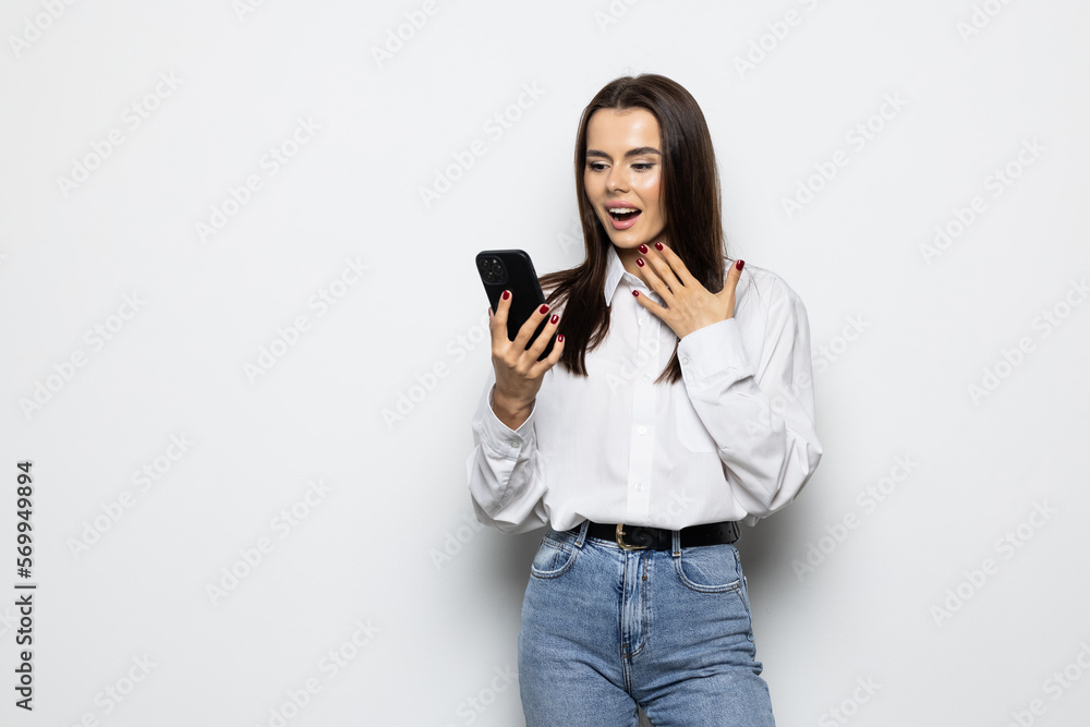 Portrait of a shocked woman using mobile phone isolated over white background Portrait of a shocked woman using mobile phone isolated over white background