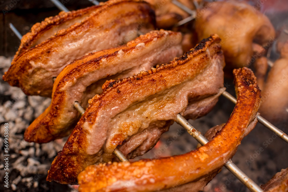 Several pieces of Liempo, or pork belly skewered on a spit and roasted on an oven at a roadside restaurant. Several pieces of Liempo, or pork belly skewered on a spit and roasted on an oven at a roadside restaurant.