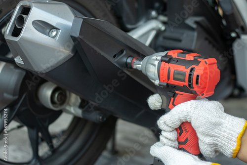 Male mechanic using motorcycle inspection tool, fixing, repairing, maintenance Vehicles to be transported by professional mechanics involve fuel, power, wrenches, tools.