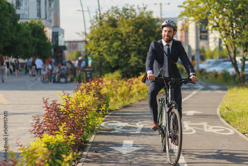 Successful executive in suit smiling, while riding on bike path outside.