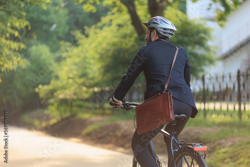 Busy male employee in suit cycling on bike to workplace.