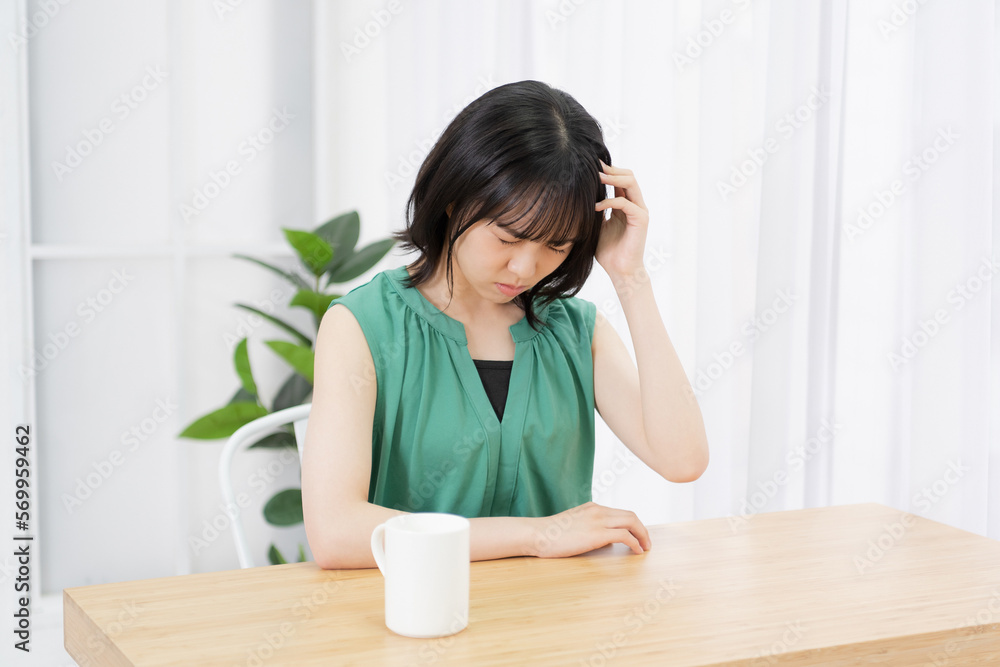リビングで悩んでいる若い女性 リビングで悩んでいる若い女性