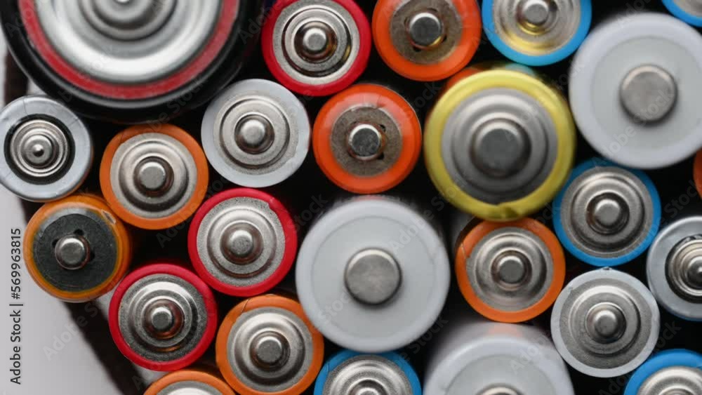 Different batteries close-up rotating on a turntable, top view. Background of colorful batteries.The concept of hazardous waste, disposal of used batteries, ecology. Different batteries close-up rotating on a turntable, top view. Background of colorful batteries.The concept of hazardous waste, disposal of used batteries, ecology.
