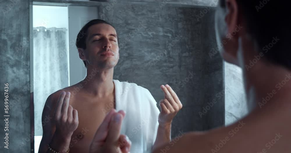 Man meditates while standing in front of mirror in bath. Young ...