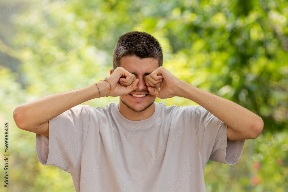 young man with allergic reaction rubbing his eyes young man with allergic reaction rubbing his eyes