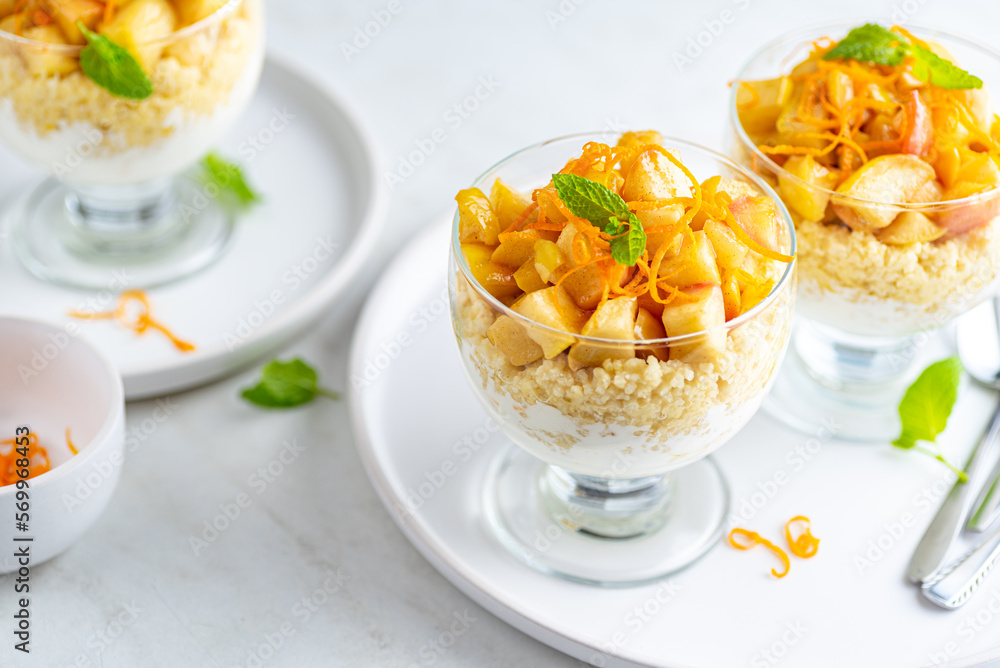 Millet groats dessert with caramelised apples, natural yoghurt and orange peel. White background