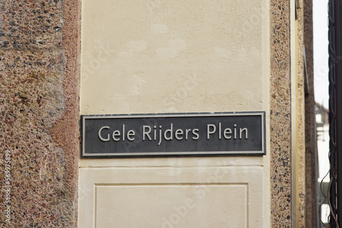 Blue street name sign of Gele Rijders Plein on a beige stone wall  in Arnhem in the Netherlands photo