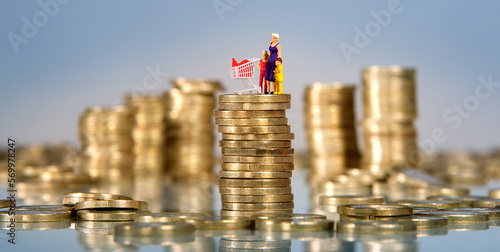 Euromünzen und Miniaturleute, Mutter mit Kindern und Einkaufswagen auf Stapel von Münzen, Inflation, Preissteigerung von Supermarktwaren und Lebensmitteln