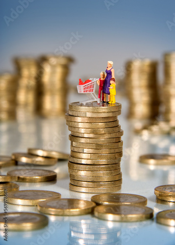 Euromünzen und Miniaturleute, Mutter mit Kindern und Einkaufswagen auf einem Stapel Münzen, Inflation, Preissteigerung von Supermarktwaren und Lebensmitteln