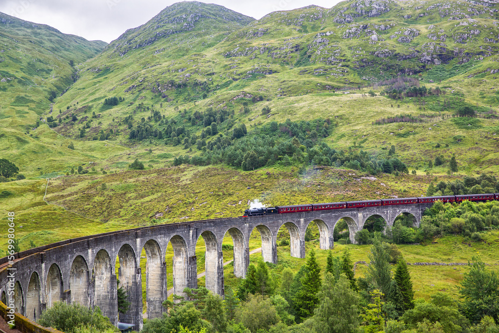 Glenfinnan railway viaduct in Scotland with the Jacobite steam train passing by