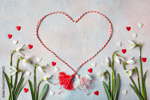 Decorative background with flowers of snowdrops, with red and white hearts, a symbol of the holiday on March 1 martenitsa, Martisor, Baba Marta, copy space.