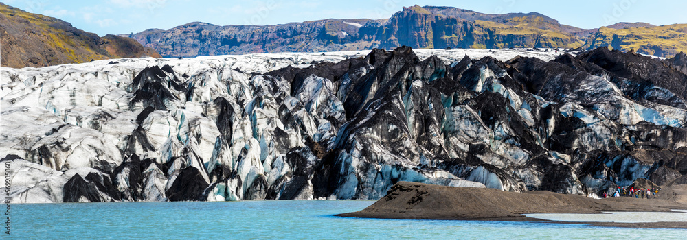Charming beautiful scenery with glacier in volcanic soot in Solheimajokull lagune, Iceland. Exotic countries. Amazing places. Popular tourist atraction. Panorama. (global warming – concept)