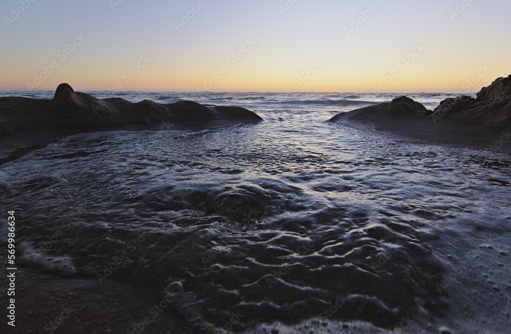 custom made wallpaper toronto digitalolas del mar entrando por las figuras de la arena, puesta de sol en la playa