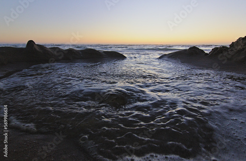 Wallpaper Mural olas del mar entrando por las figuras de la arena, puesta de sol en la playa Torontodigital.ca