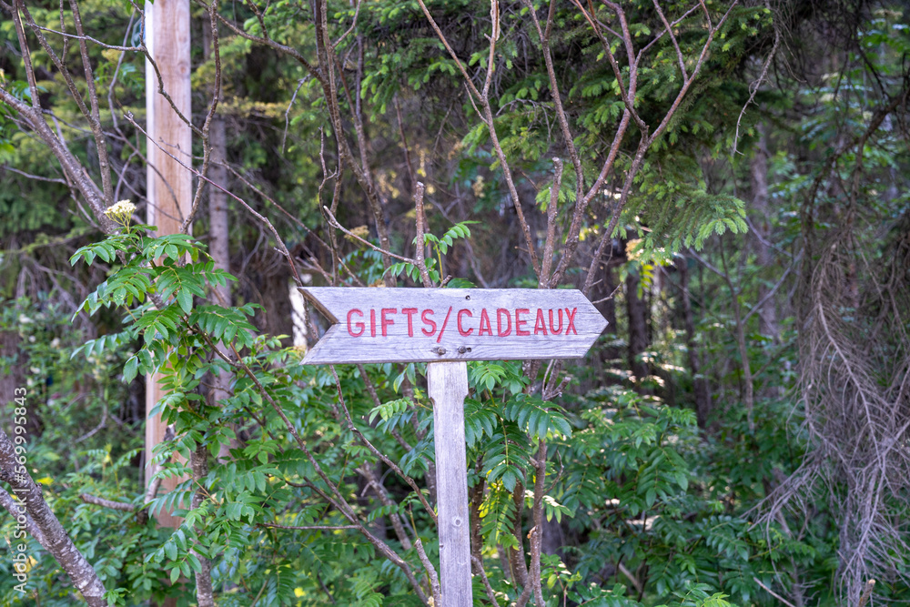 Wood sign with an arrow pointing to a gift shop, also in French - Cadeaux