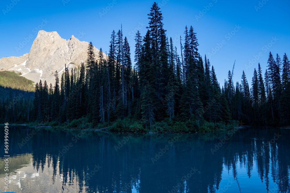 Beautiful sunset on Emerald Lake in Yoho National Park, with calm water and sun beaming on mountain peaks