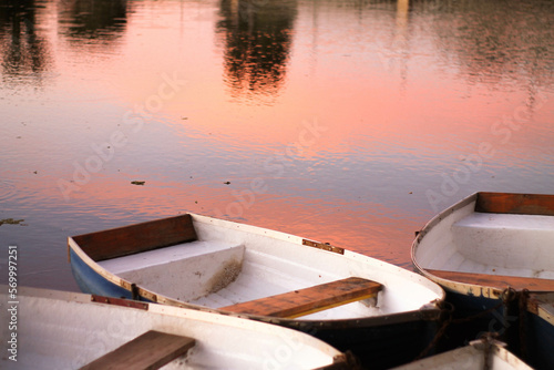 Barcas pequeñas en un lago con una puesta de sol.	