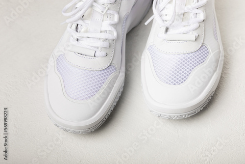 Pair of white shoes on a white texture background. Sport shoes. Unisex. Street style.