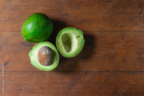 Сut avocado lie on a wooden table.