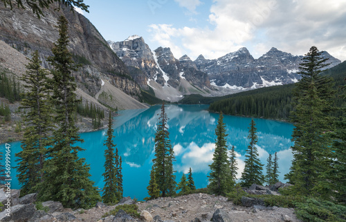 View of Moraine lake surrounded by mountains and pine trees during summer time, Rocky mountains, Valley of the Ten Peaks, Banff National Park, Alberta, Canada