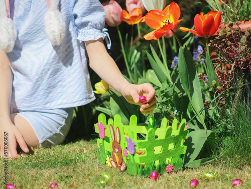 Photography Hands caucasian teenage girl lays a chocolate easter egg in a green easter felt