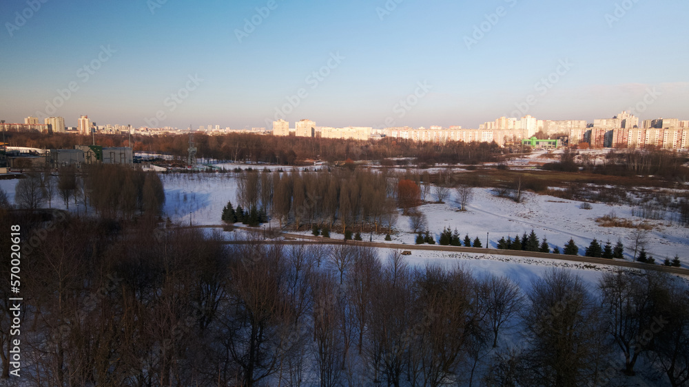 A winding bike path in a city park. City park in winter. Snow lies on the ground. Aerial photography.