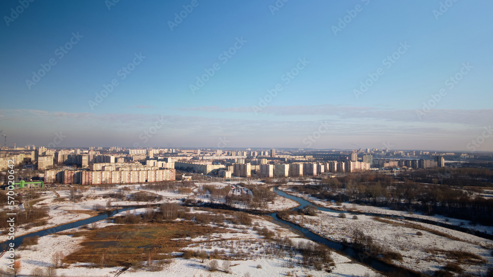City park in winter. Snow lies on the ground. A meandering river flows. Aerial photography.