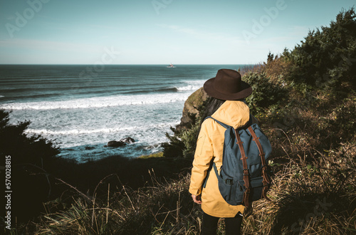 A girl standing and looking st the Tillamook Rock Light, located approximately 1.2 miles offshore from Tillamook Head photo