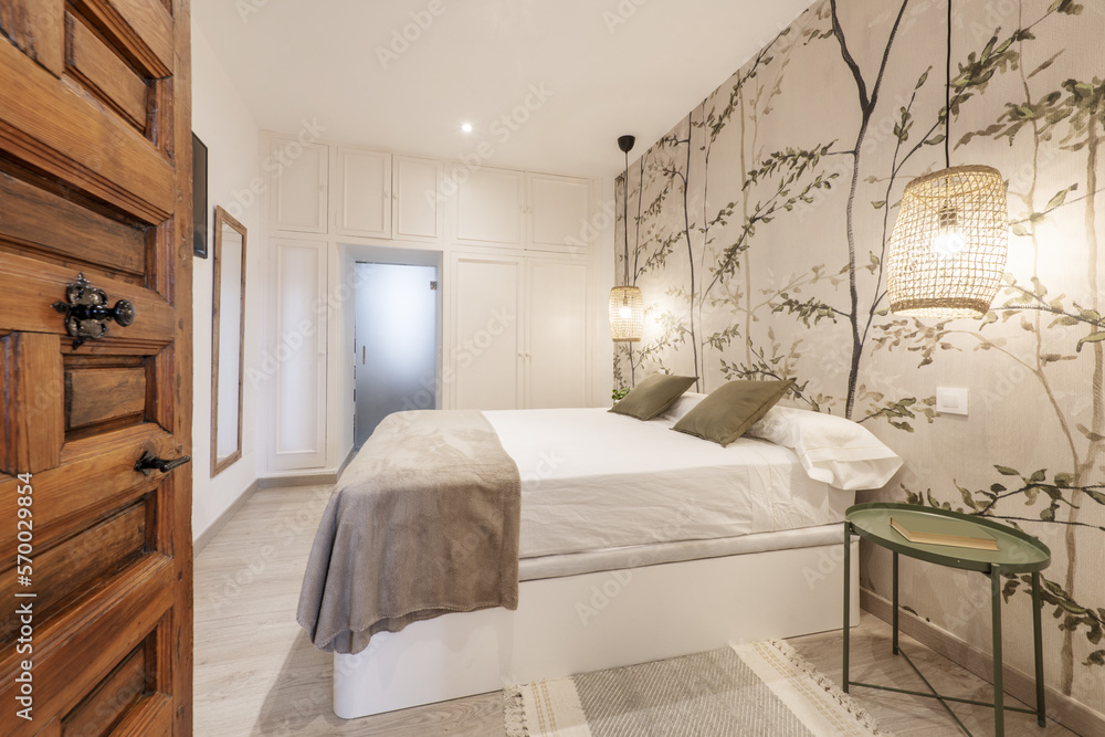 Bedroom with a double bed decorated with wallpaper, a bed with a white