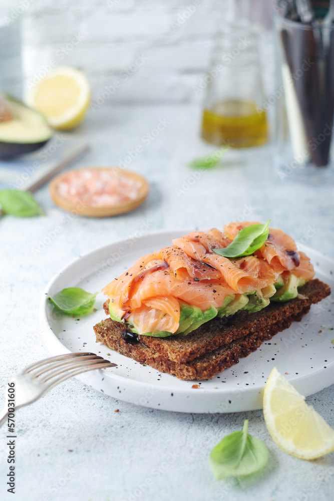A rye bread sandwich with avocado and salmon	