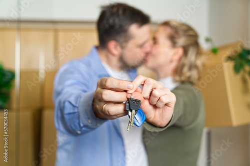 Couple showing keys to new apartment. real estate mortgage  loan concept. moving in new house. Young smiling couple holding their new house keys. first own apartment or house.