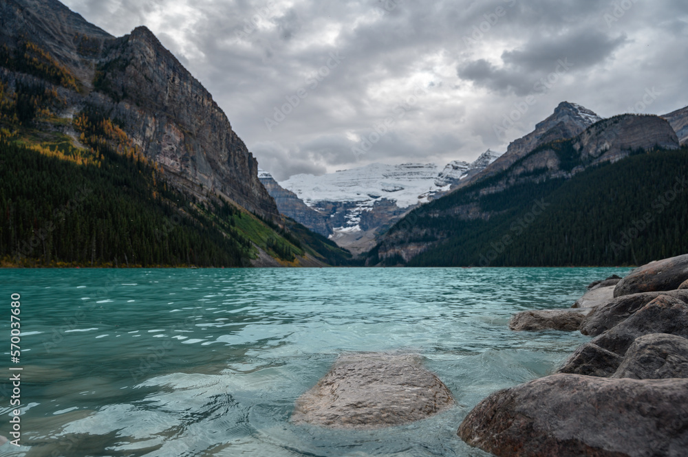 Panoramic image of Lake Louise (Canada) in summer, with crystal blue water and snow on the mountains in the background.