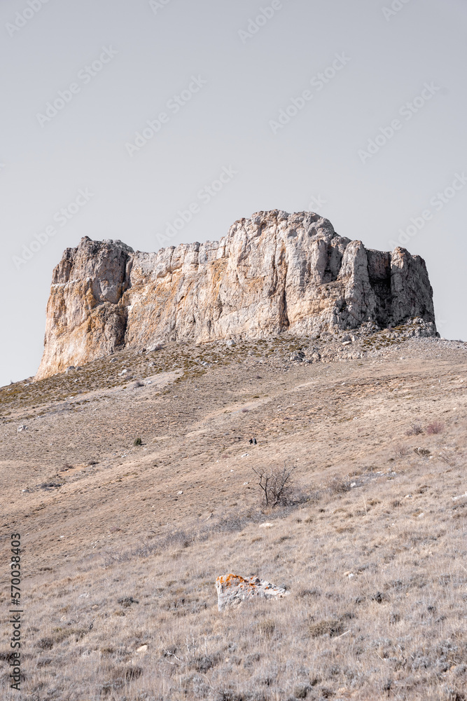 Fototapeta premium Two adults are hiking to a big limestone formation in the summit