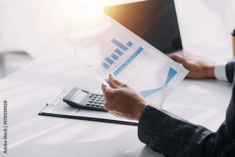 Asian Business woman using calculator and laptop for doing math finance on an office desk, tax, report, accounting, statistics, and analytical research concept Asian Business woman using calculator and laptop for doing math finance on an office desk, tax, report, accounting, statistics, and analytical research concept