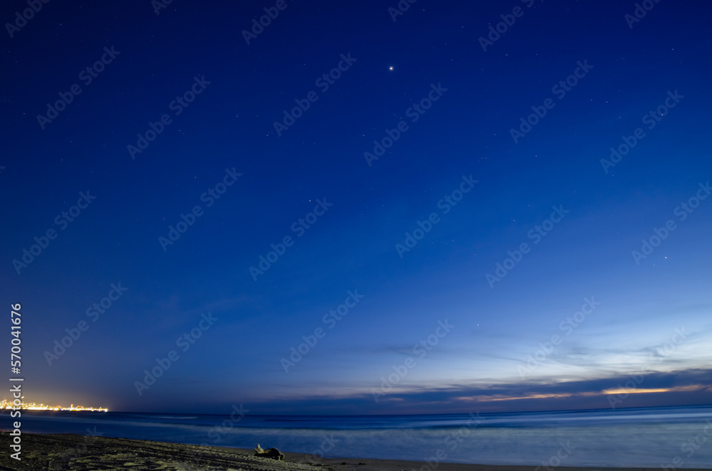 Obraz premium Night landscape with sea and sandy beach. Sunset sky with stars.