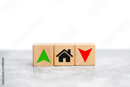Interest rate financial and mortgage rates concept real estate. Wooden cube block with house icon, symbol arrow up and down. on the table.