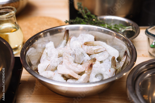 raw shrimps in a saucepan on a wooden table