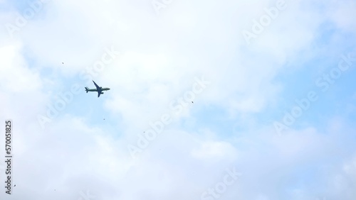 A plane flies in the blue sky.