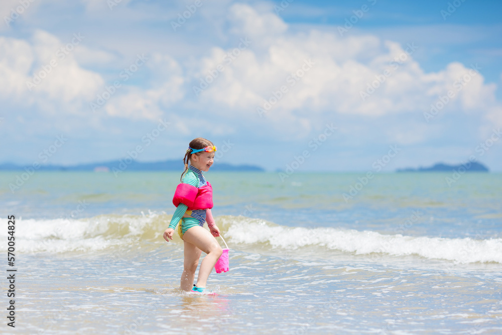 Kids play on tropical beach. Sand and water toy.