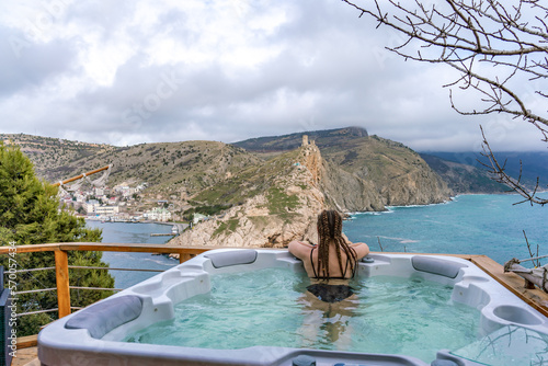 Spa woman sea view. Find time for yourself. A woman in a black swimsuit is resting admiring the beautiful view